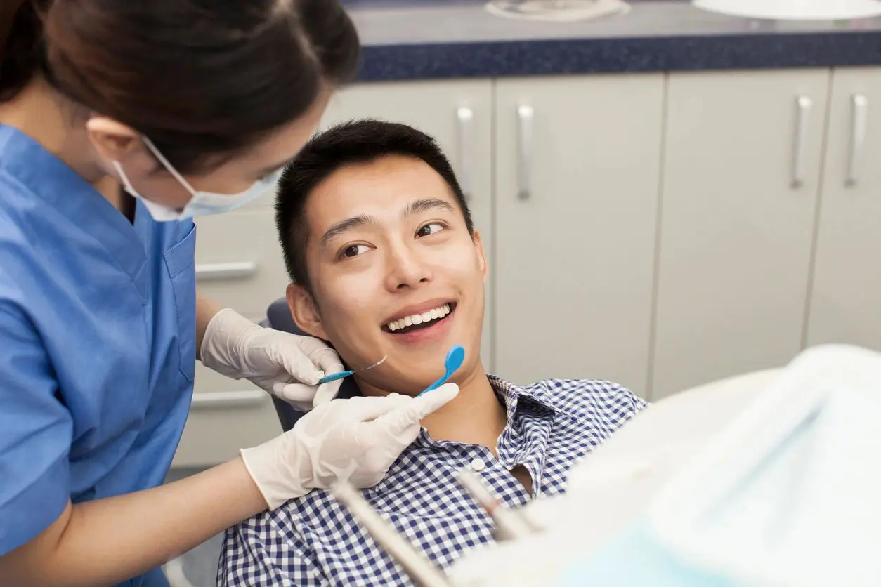 img A dentist is examining the teeth of a patient.
