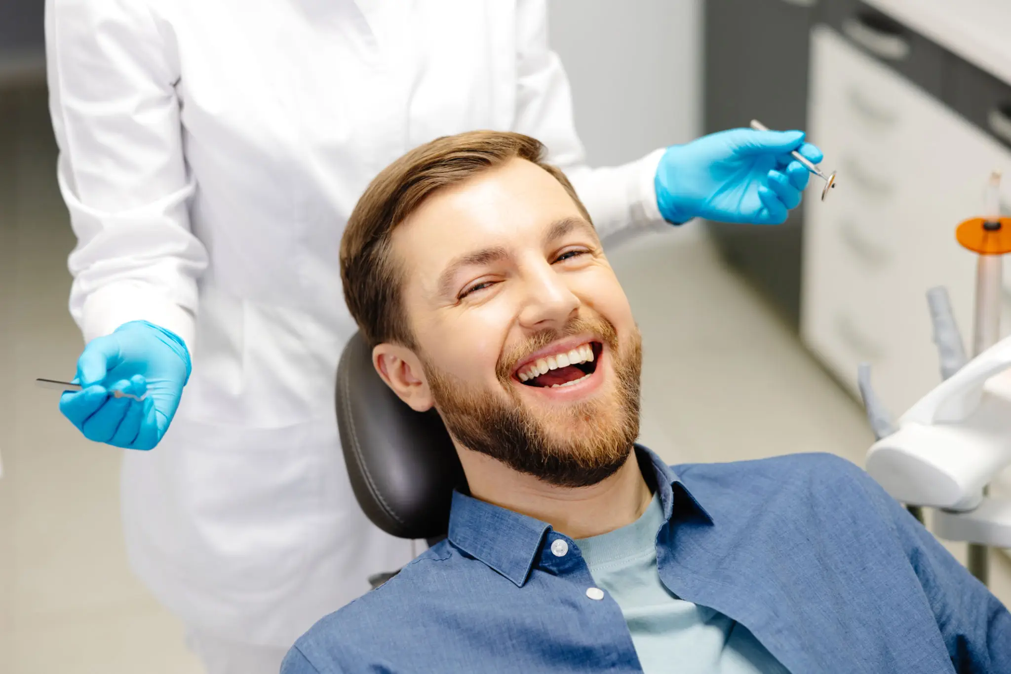 682cdf1a62e56_5985705b-3c98-4601-9d73-59aecf3ddce6 A man smiling while being examined by an orthodontist.